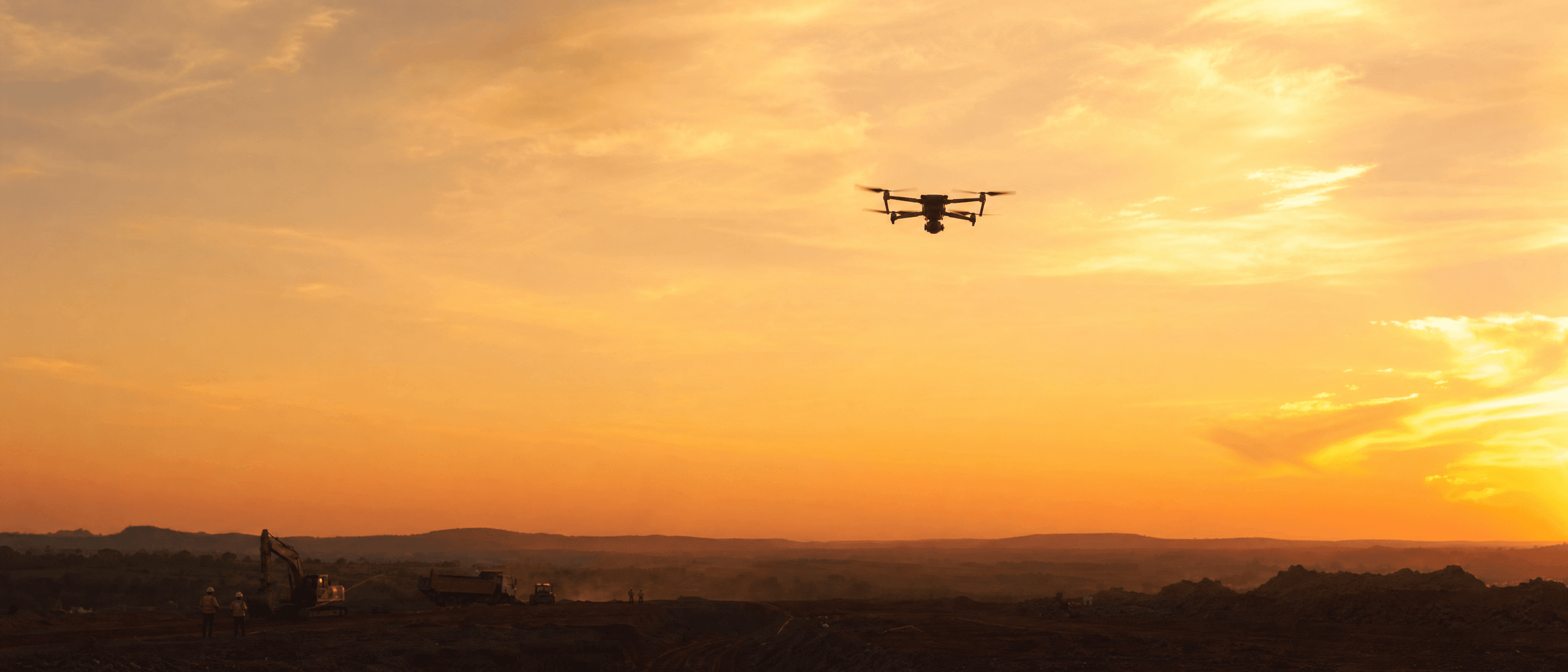 Drone sobrevoando obra ao entardecer